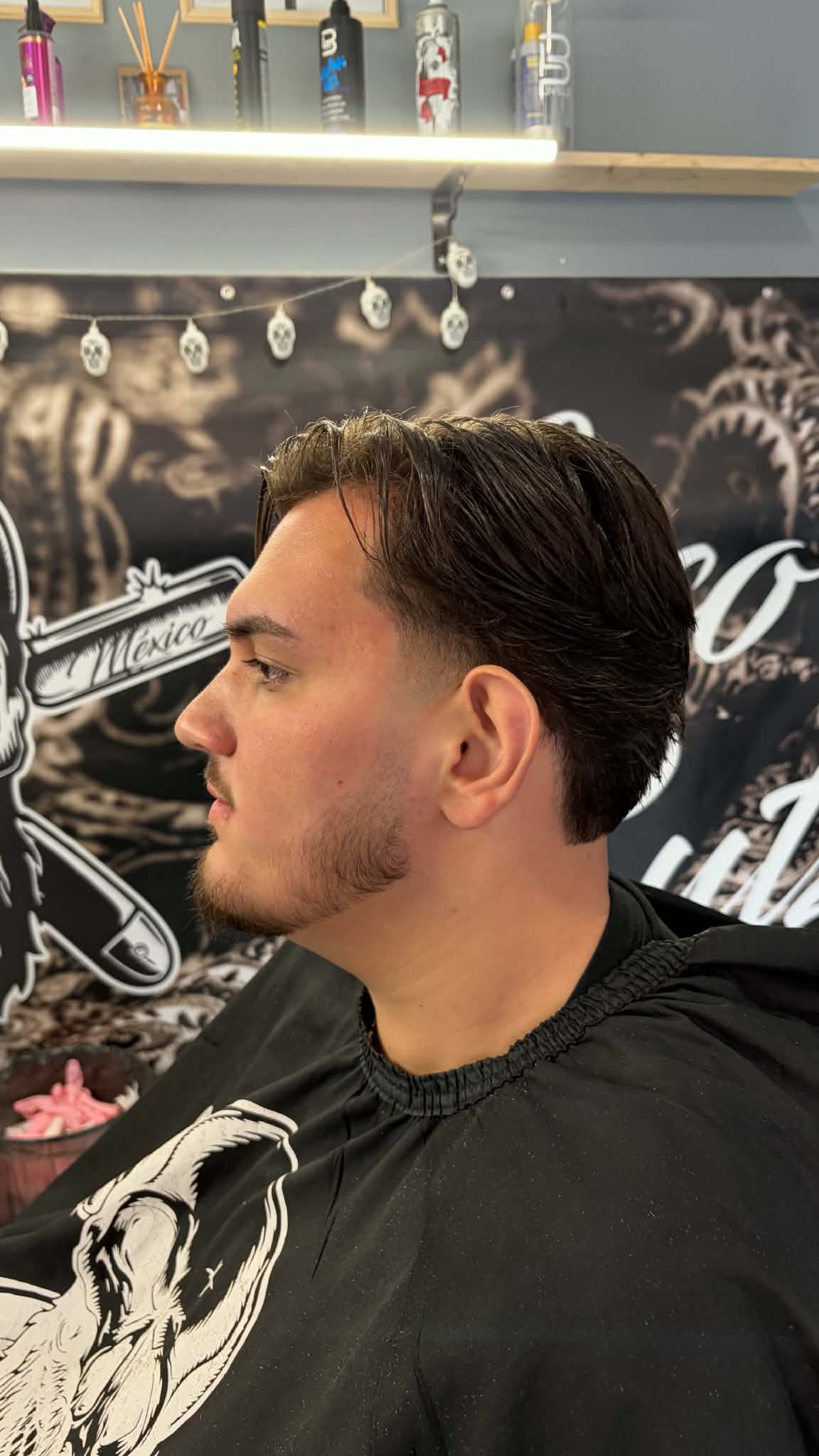 Vendég a Loco Cutz barber shop táblája előtt, Szécsény